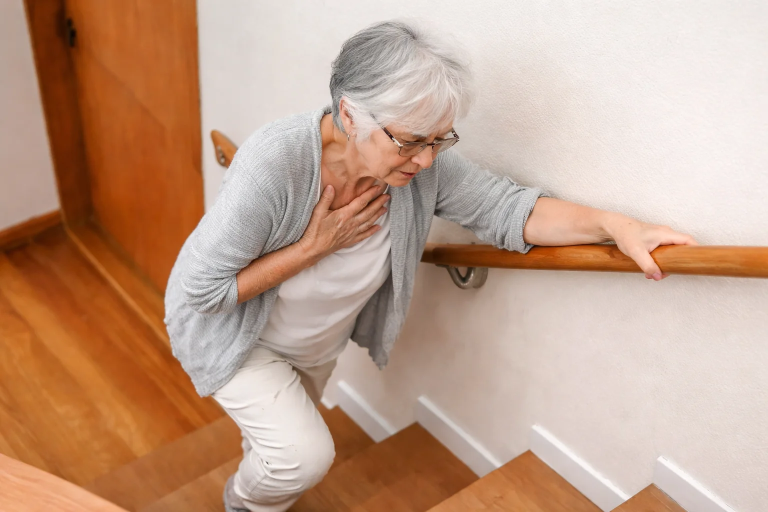Older woman struggling to climb stairs due to breathing difficulty
